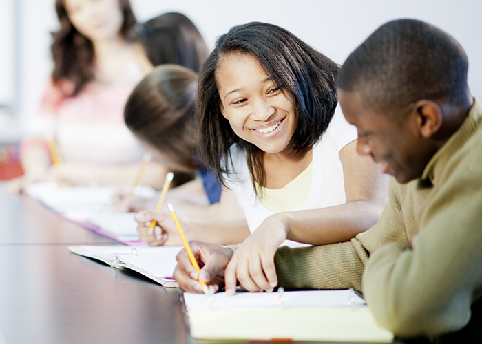 Two students smiling while they study together.