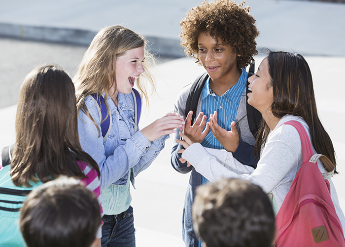 Three students talking together excitedly.