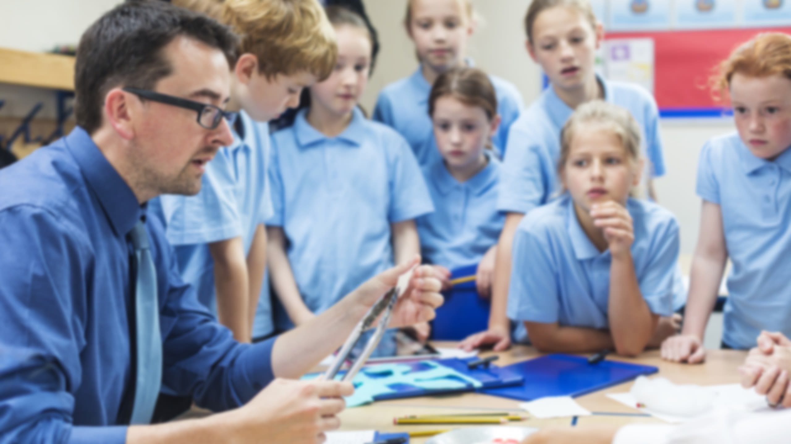 Students watching a teacher demonstrate an art technique.
