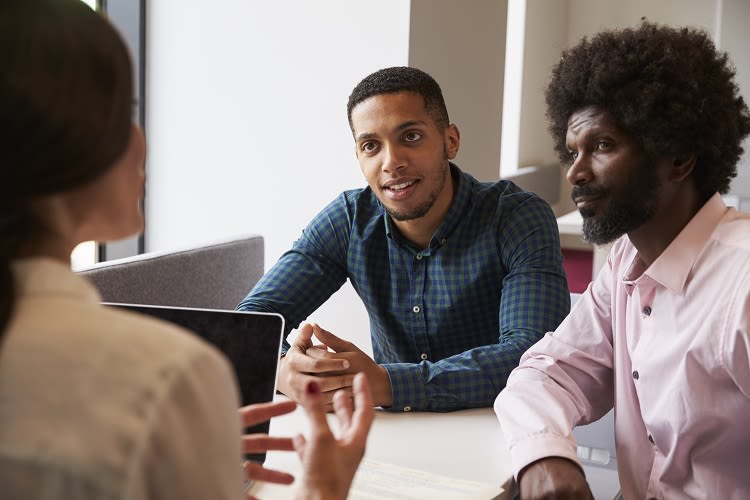 Two teachers listening carefully to a third teacher.