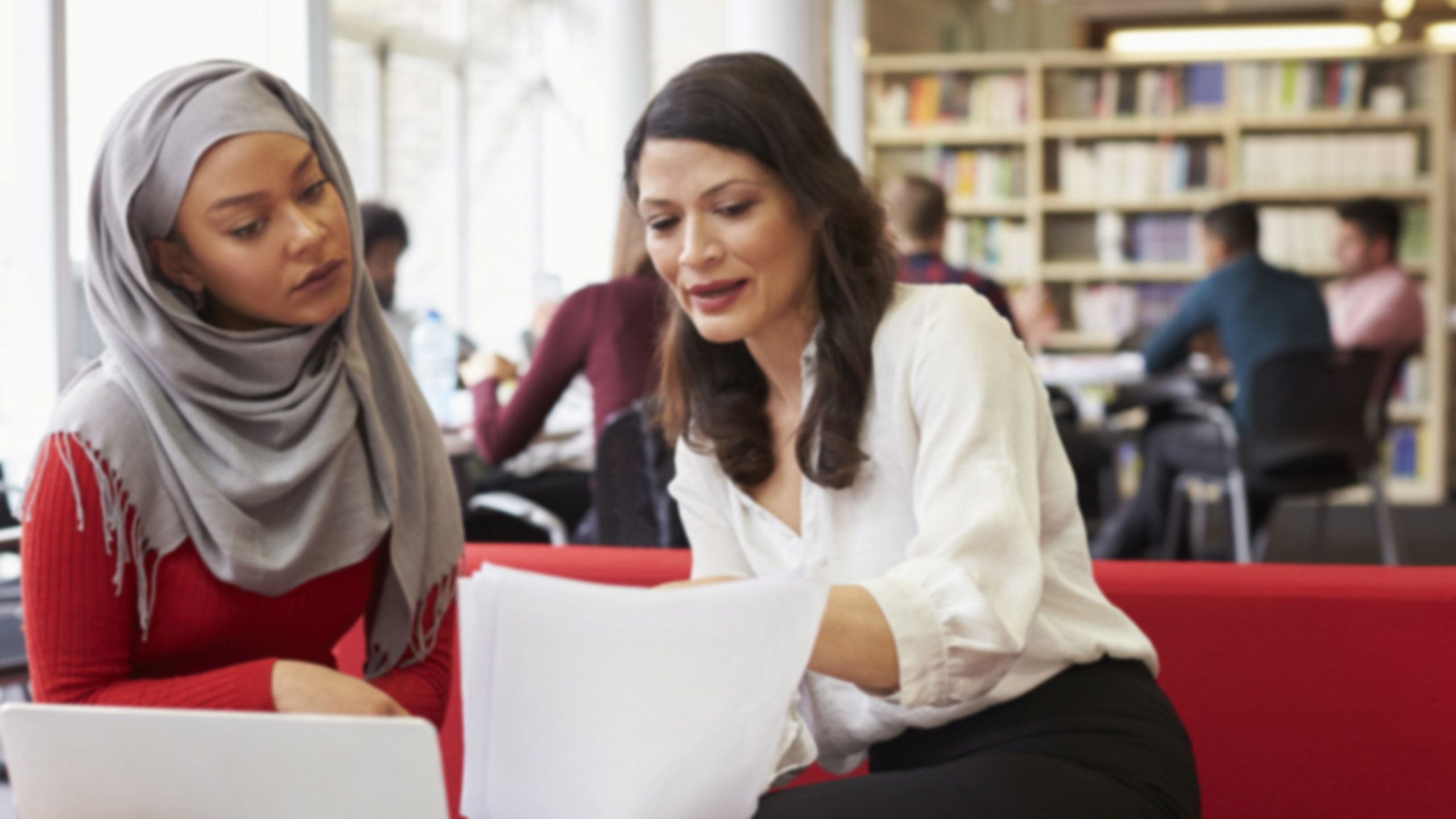 Tow women discussing a paper