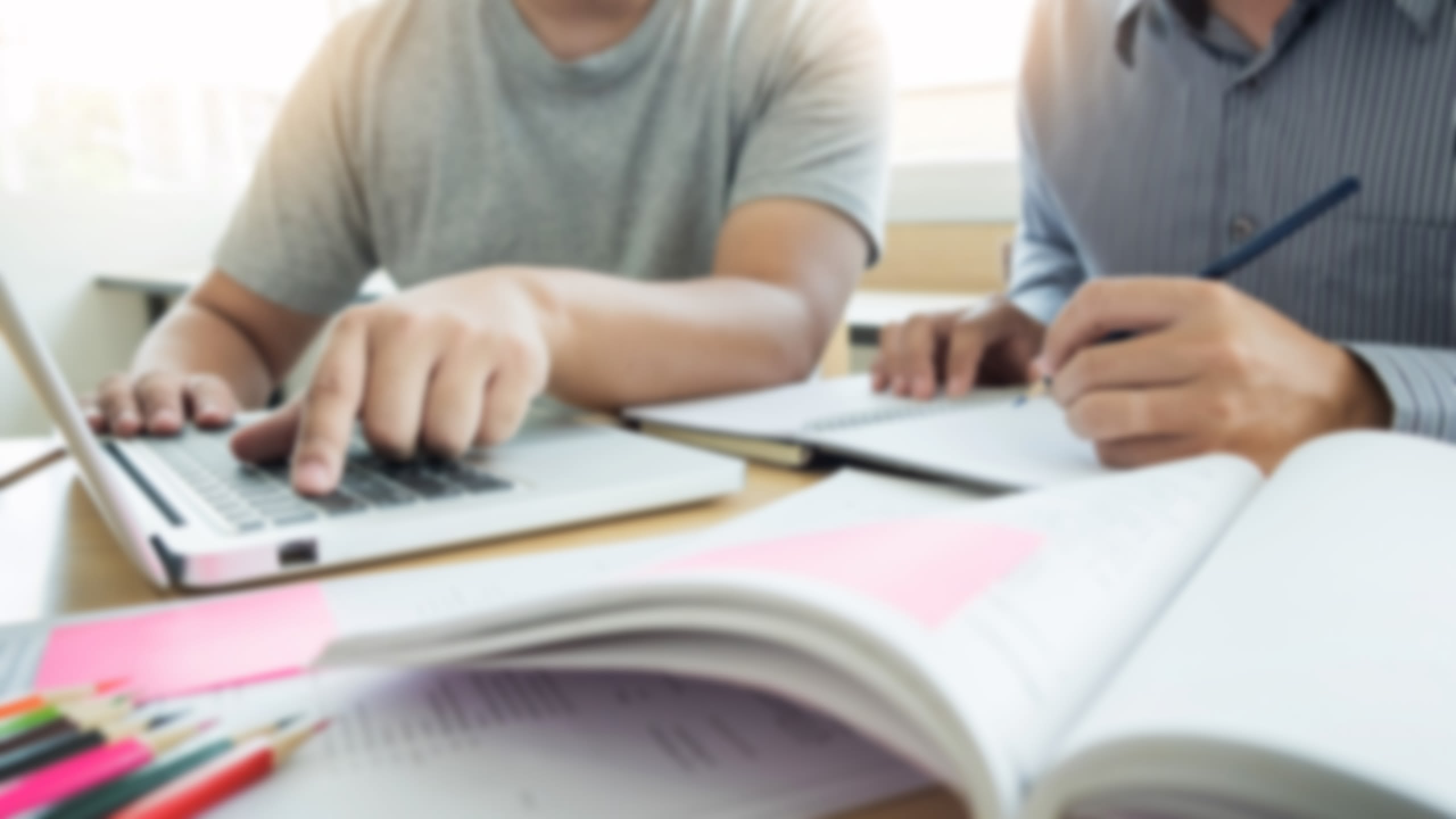 Two students working at a laptop.